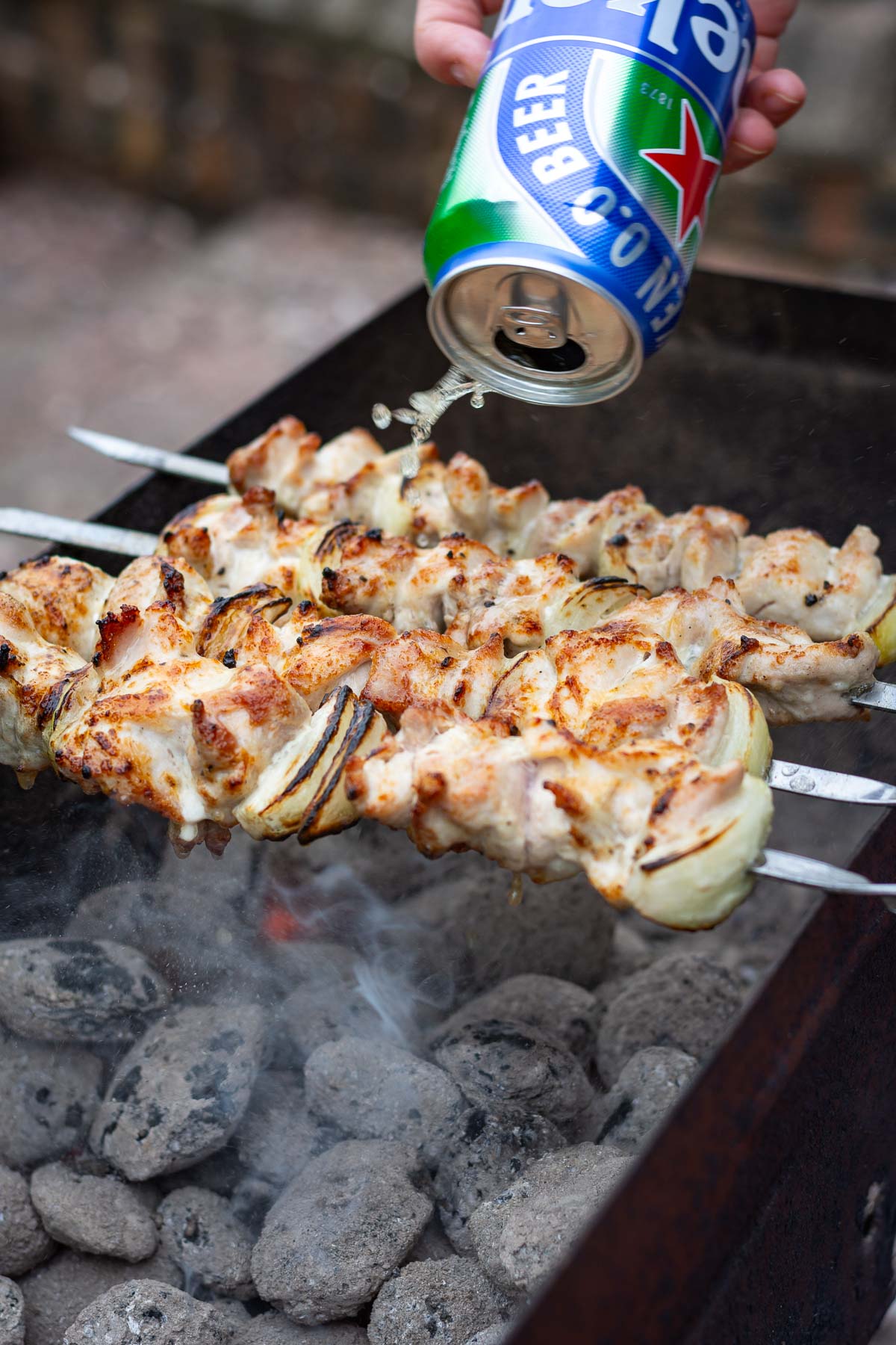 Spraying Chicken shashlik with beer.