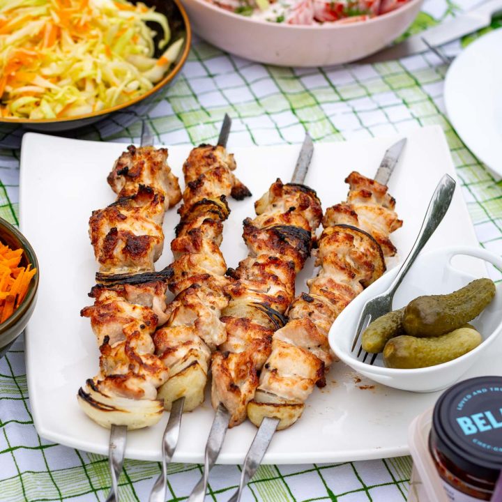 Mayo marinated chicken shashlik skewers on a large white square plate.