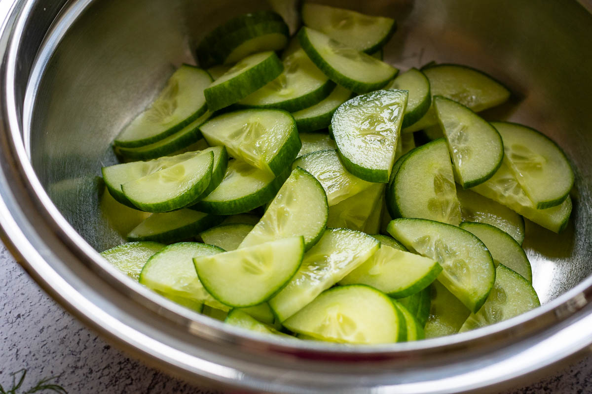 English cucumber slices in a metal bowl. 
