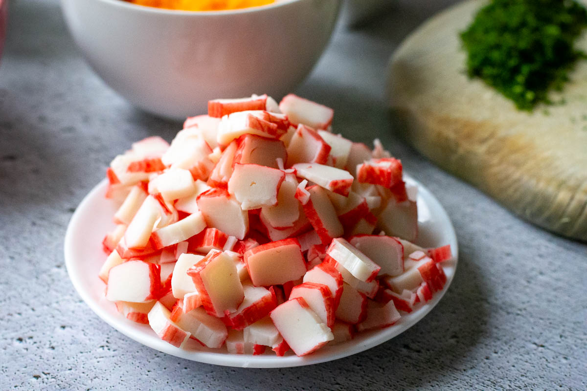 Chopped imitation crab sticks on a small white plate.