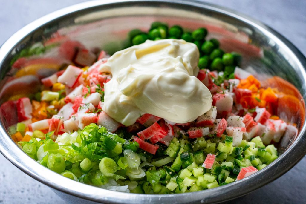 All Crab stick and rice salad ingredients in a large mixing bowl.
