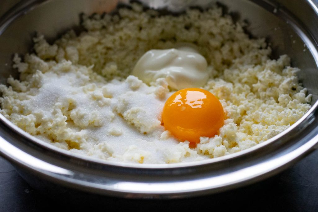 All the filling ingredients for the Lithuanian sweet cheese buns in a metal bowl before mixing.