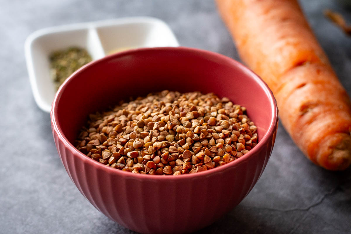 Buckwheat groats in a small red bowl.