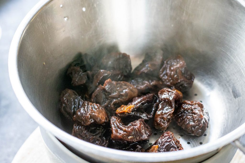 DRained prunes in a colander.