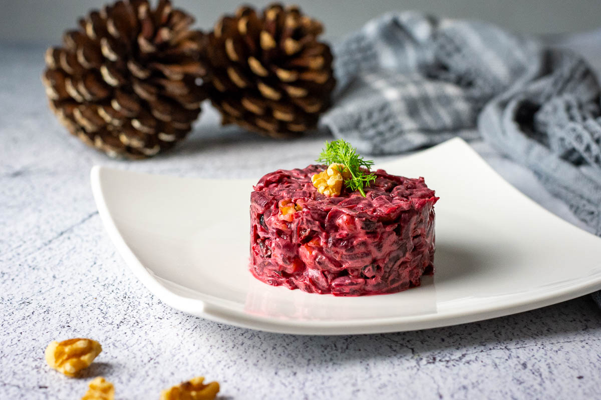 Beetroot and Prune Salad Served as an appetizer on a square white plate.