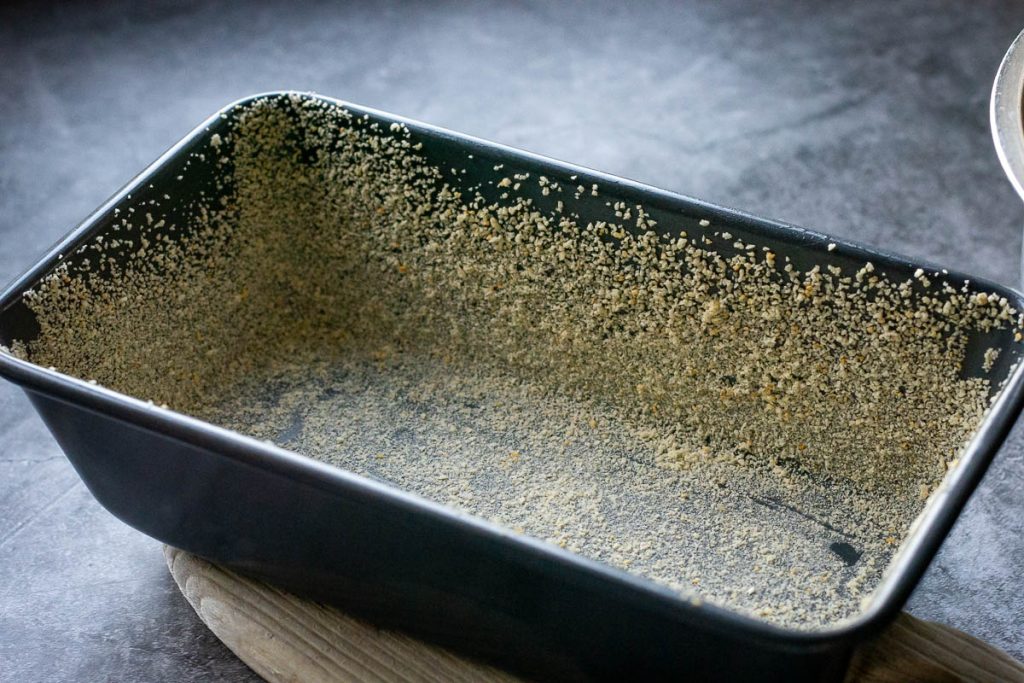 A greased and breadcrumbed loaf pan for the meatloaf.