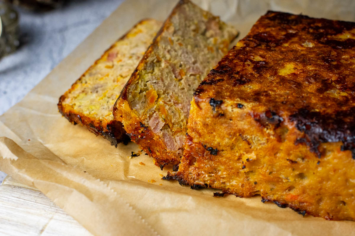Sliced Lithuanian meatloaf, known as netikras zuikis, on a piece of parchment paper.