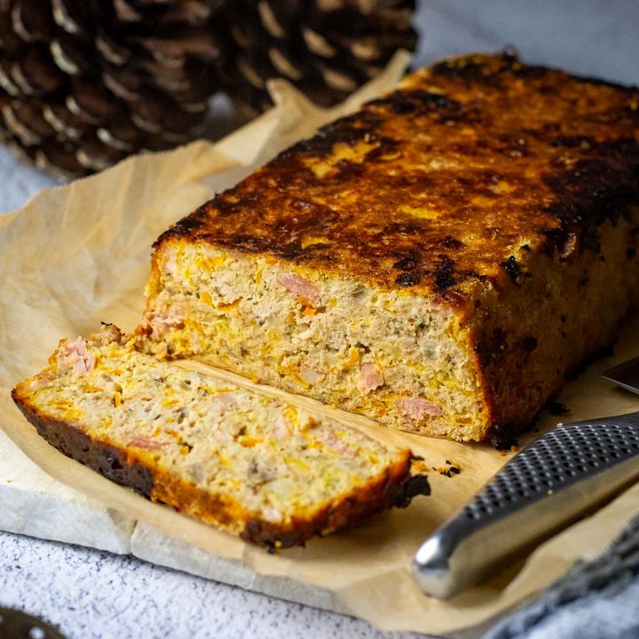 Lithuanian meatloaf with apples and bacon with one slice cut exposing the interior.