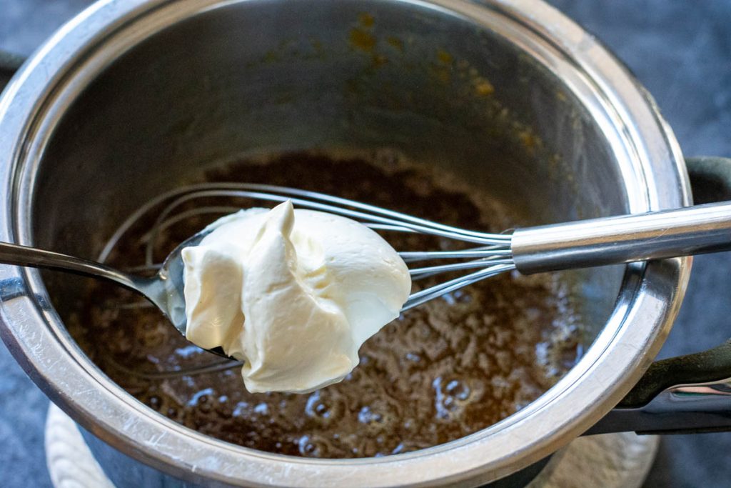Adding sour cream into the gingerbread cookie dough mix.