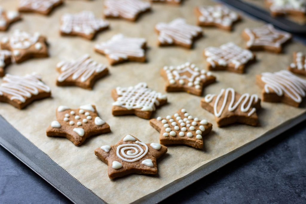 Lithuanian gingerbread cookies with orange icing on a baking sheet. 
