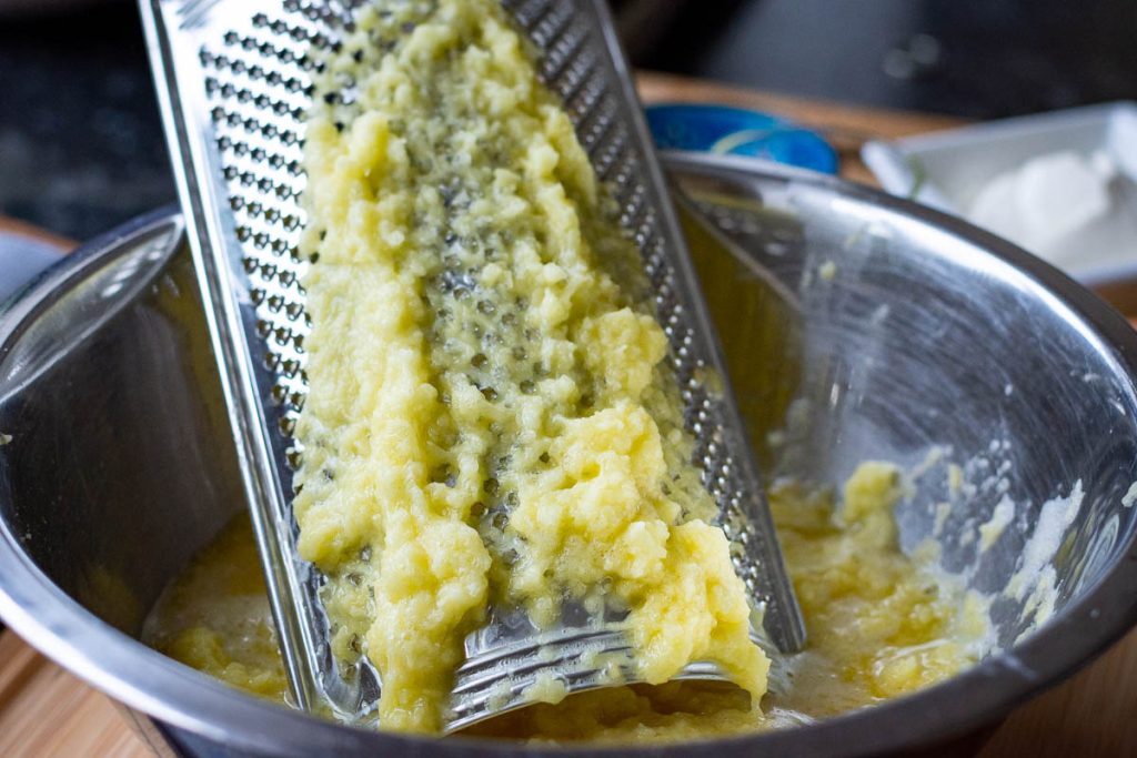 Grating potatoes on a zester side of the the grater.