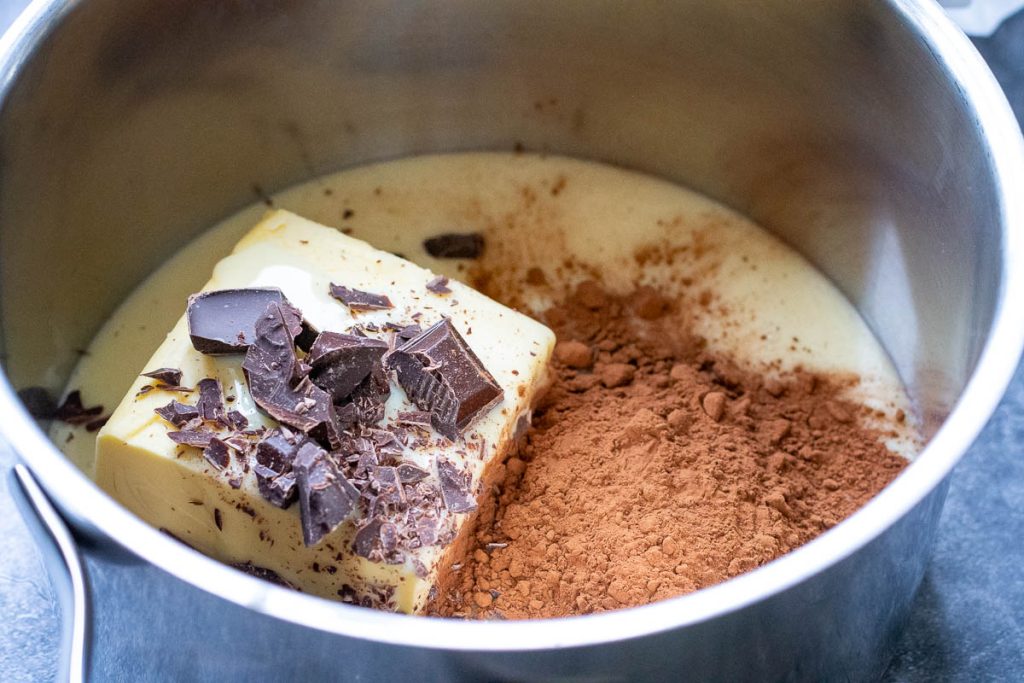 Condensed milk, butter, cocoa powder and chocolate in a large saucepan.