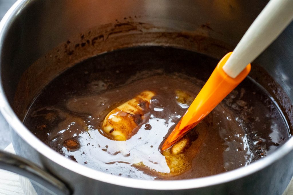 The chocolate mixture for lithuanian lazy cake melting in a pan.