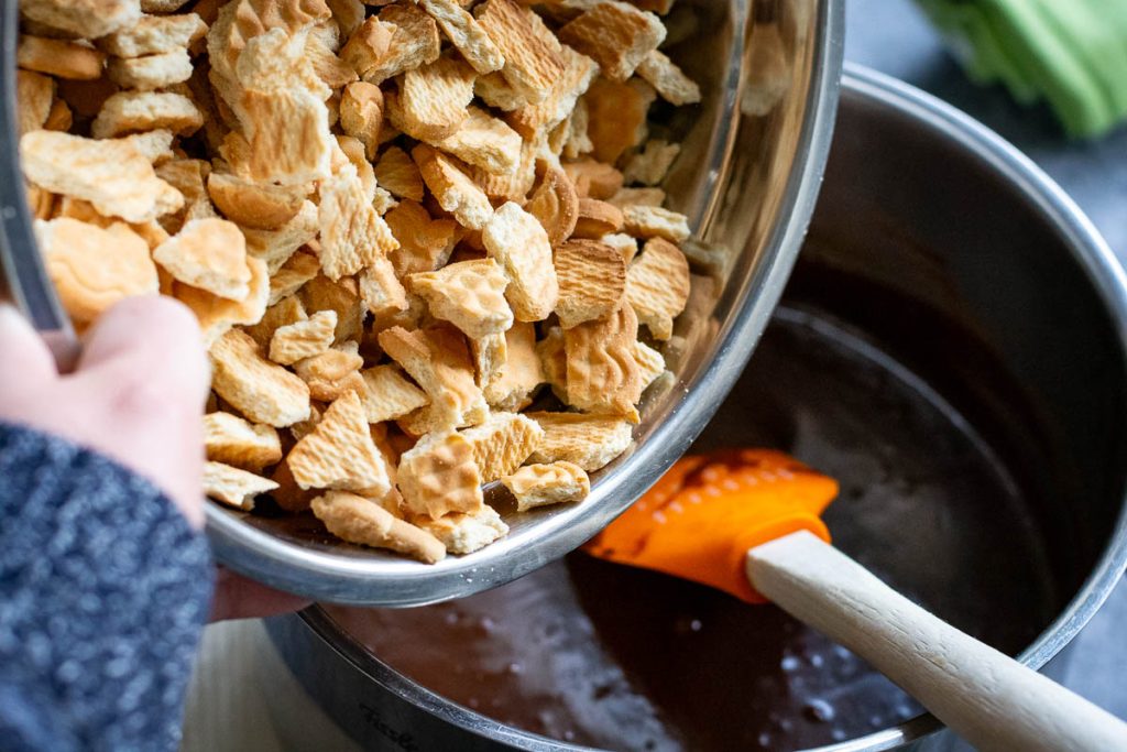 Adding broken up cookies into the chocolate mixture.