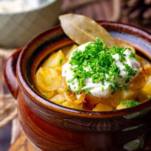 Lithuanian version of Chanakhi with pork in a clay pot topped with sour cream and parsley.