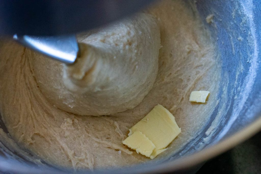 Adding thin slathers of butter to the mixed dough. 