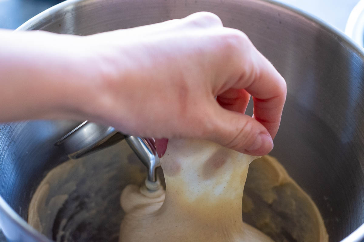 Stretching the dough thinly so that light can be seen through it without the dough tearing. 