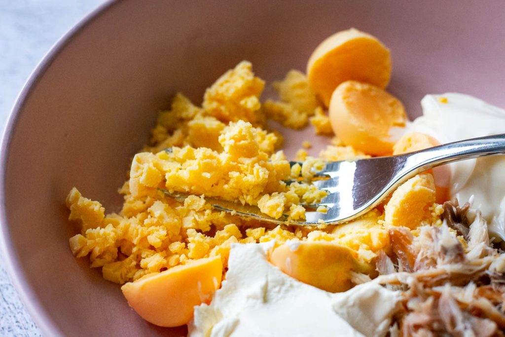 Mashing egg yolks with a fork. 