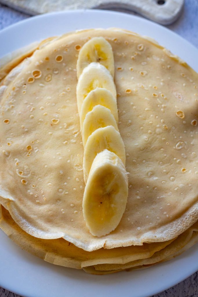 Sliced bananas in the centre of the Lithuanian crepe.