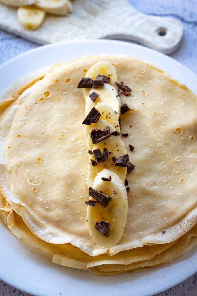 Chopped chocolate scaterred on top of sliced bananas.