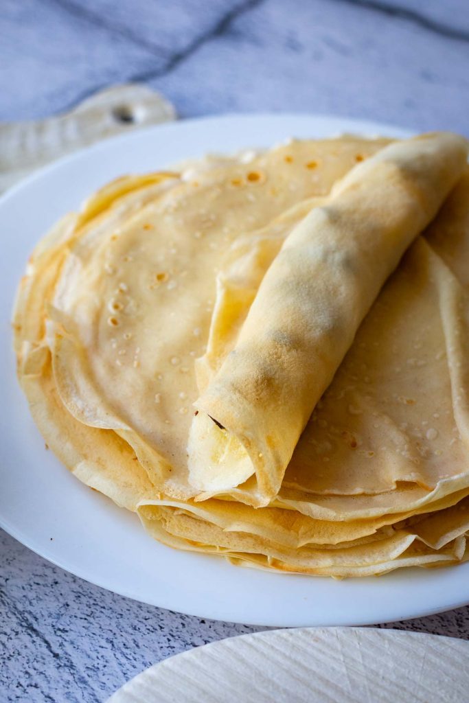 Rolling the crepe around the filling.