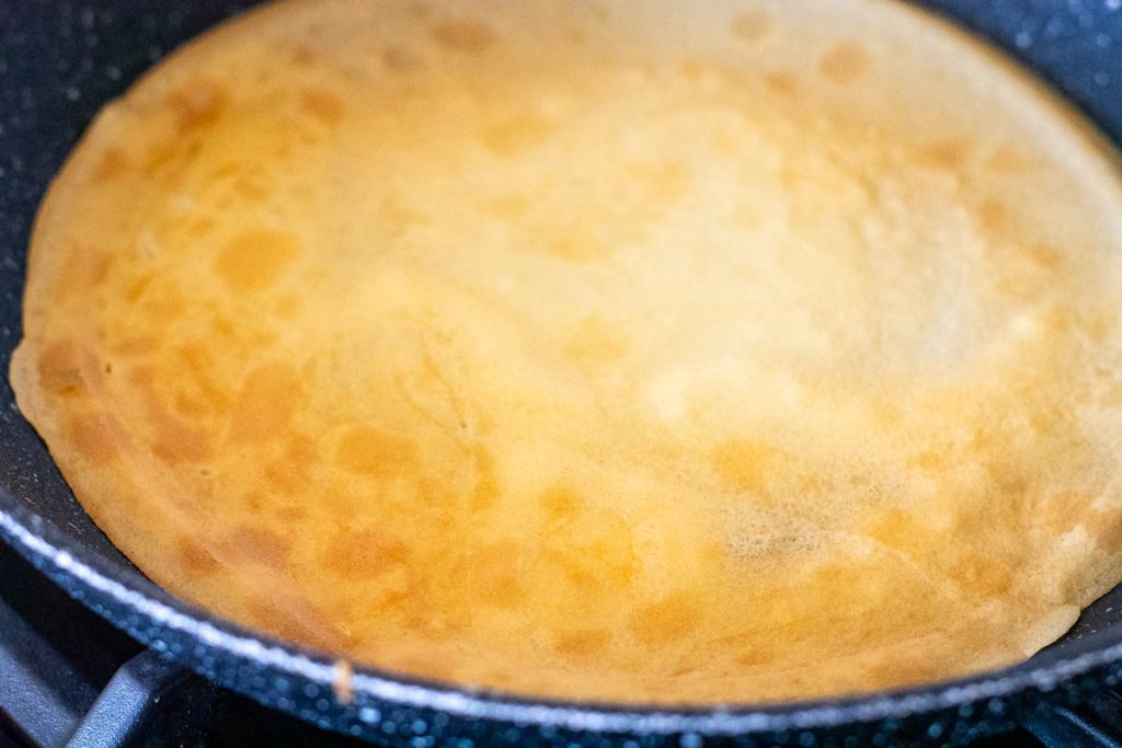 Flipped crepe in a frying pan.
