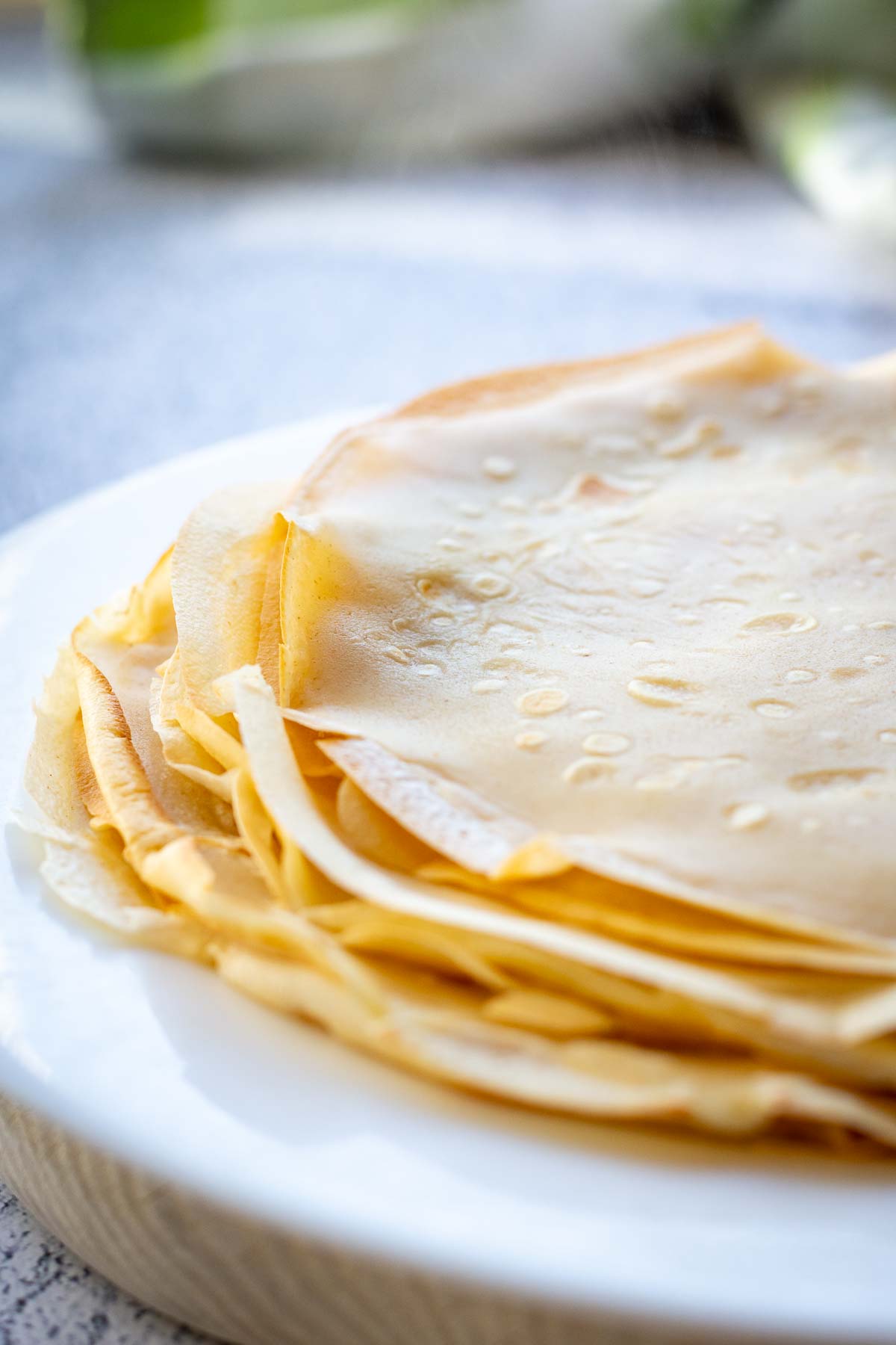 A stack of thin Lithuanian crepes on a white plate.