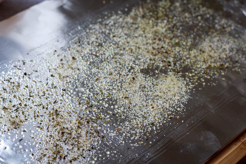 Oiled piece of alumun foil with herbs, garlic powder and salt and pepper sprinkled on top.