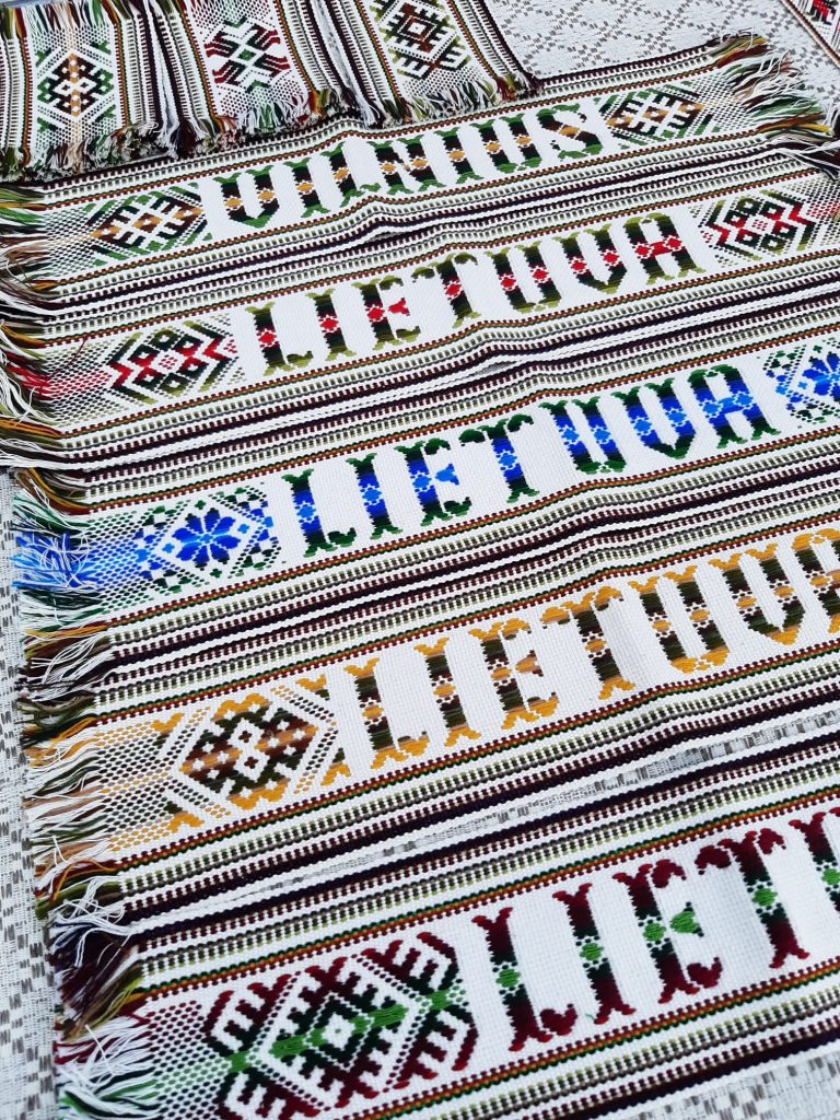 Mebroidered and traditionaly woven fabrics with the word Lietuva (Lithuania).