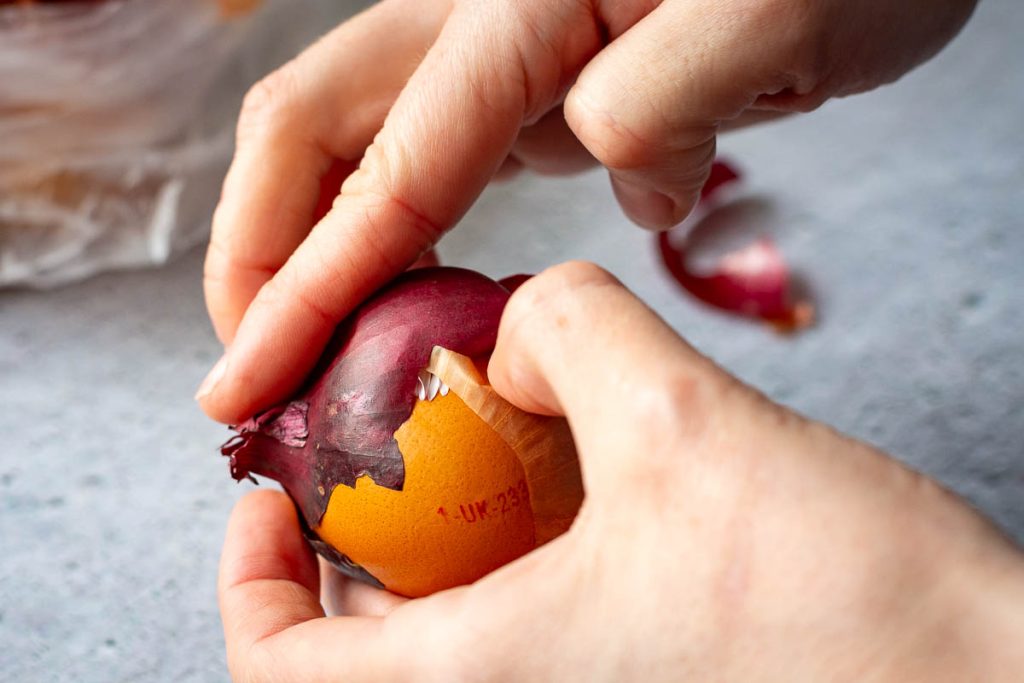Pressing onion skins around the egg. 