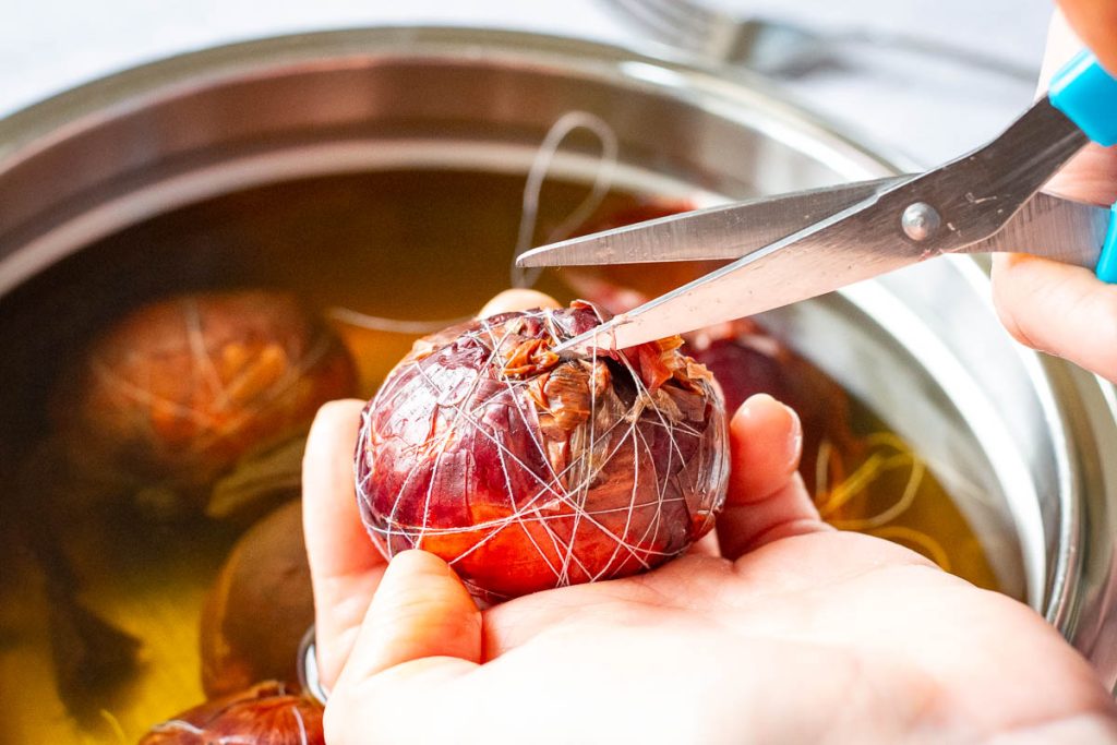 Cutting the thread around the onion skin eggs. 
