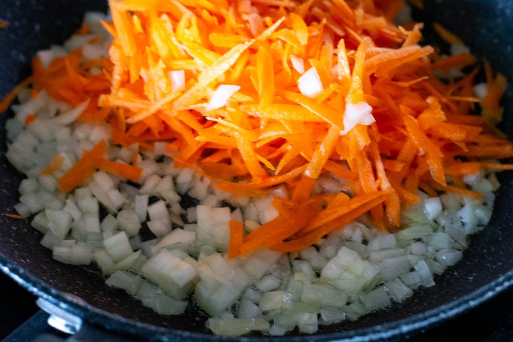 Carrots and onions in a pan.