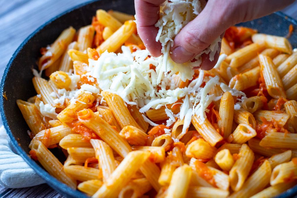 Scaterring grated cheese on top.