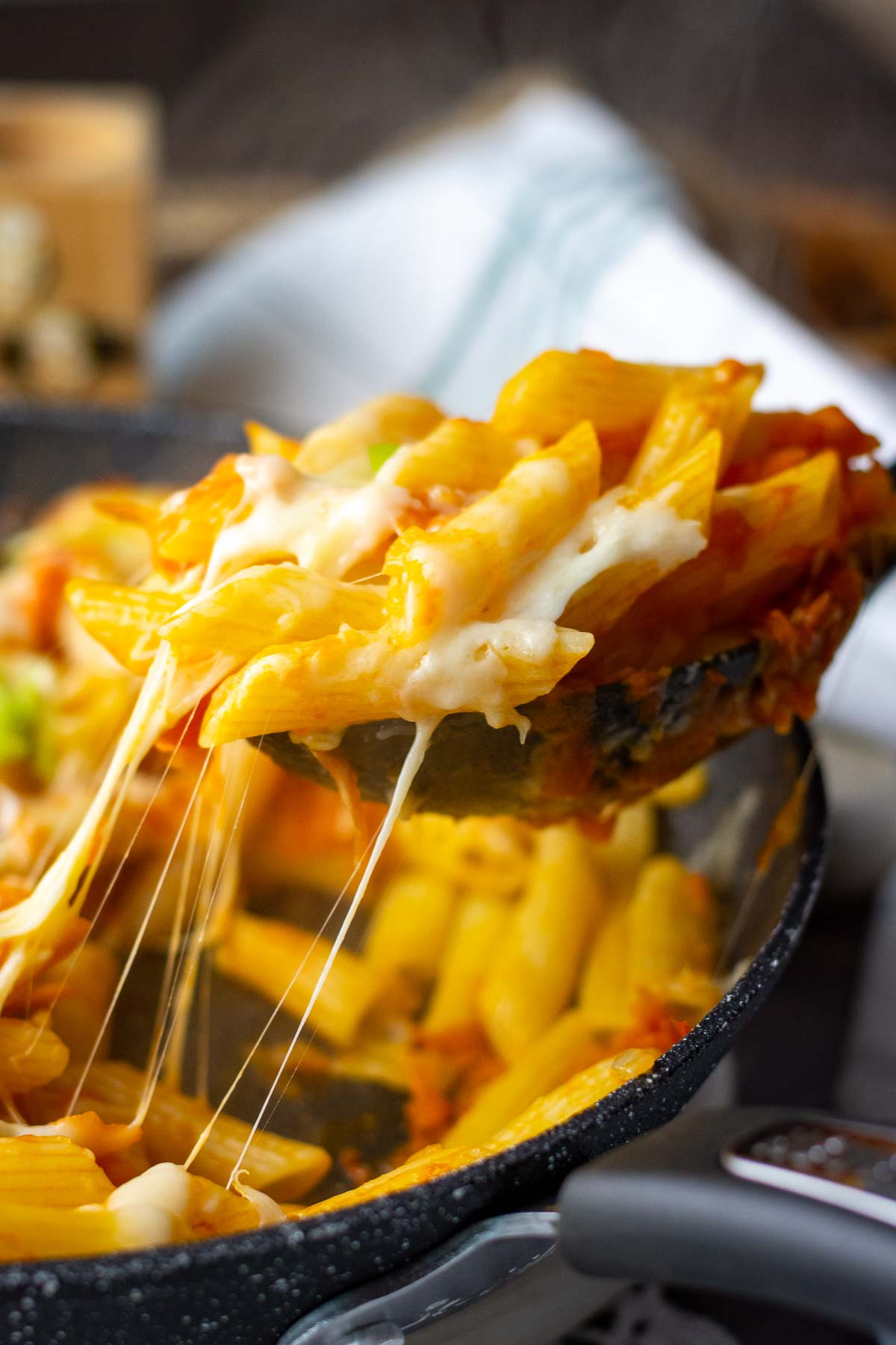 Taking a spoonful of cheesy pasta from the pan.