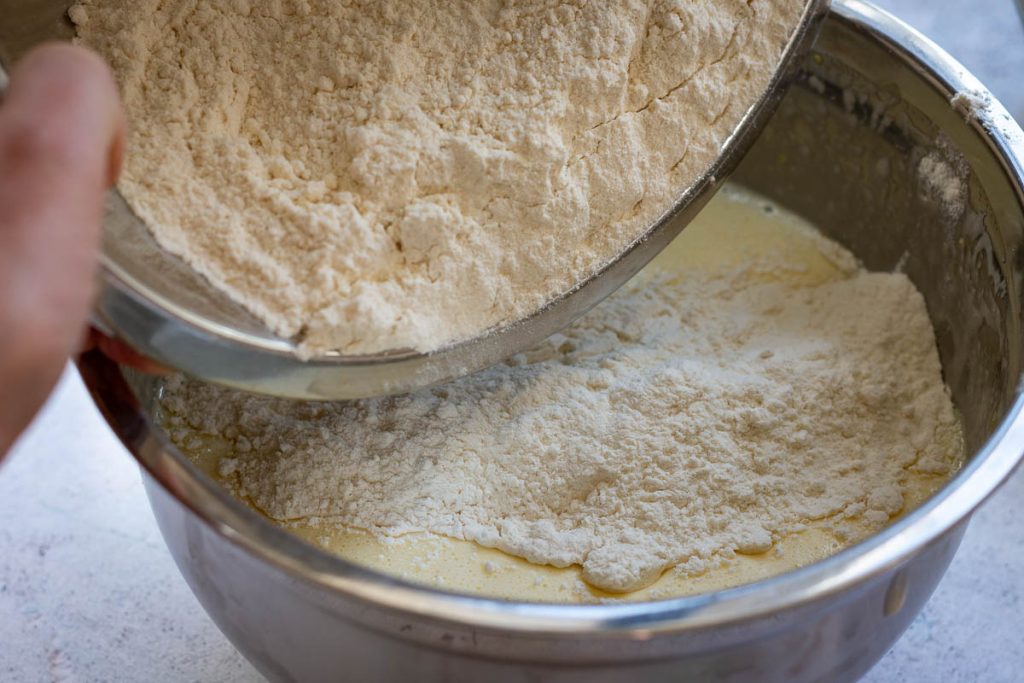 Tipping the flour mixture into the wet ingredients. 