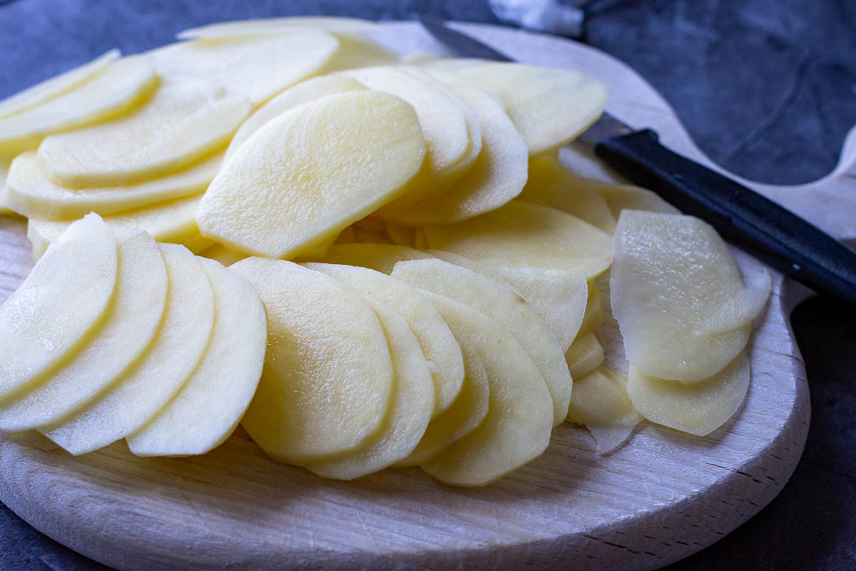 Sliced potatoes on a wooden board. 
