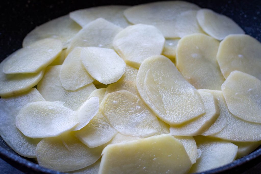 Sliced potatoes in a frying pan. 