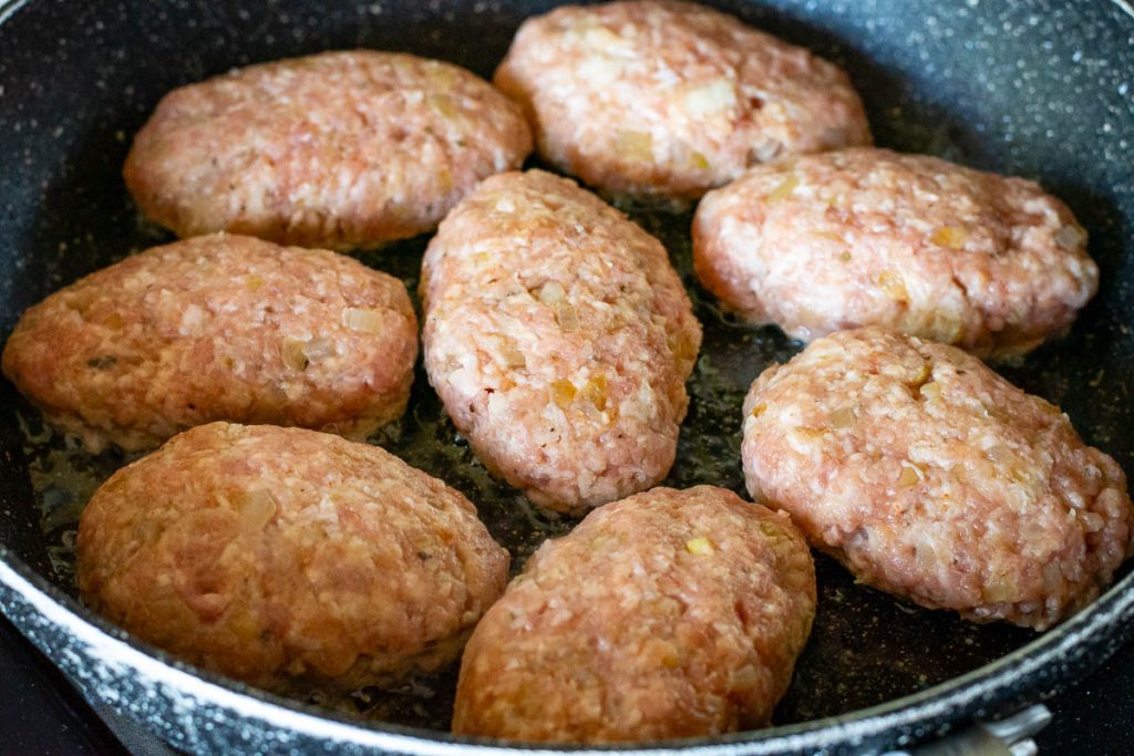 Pork meatballs in a frying pan.