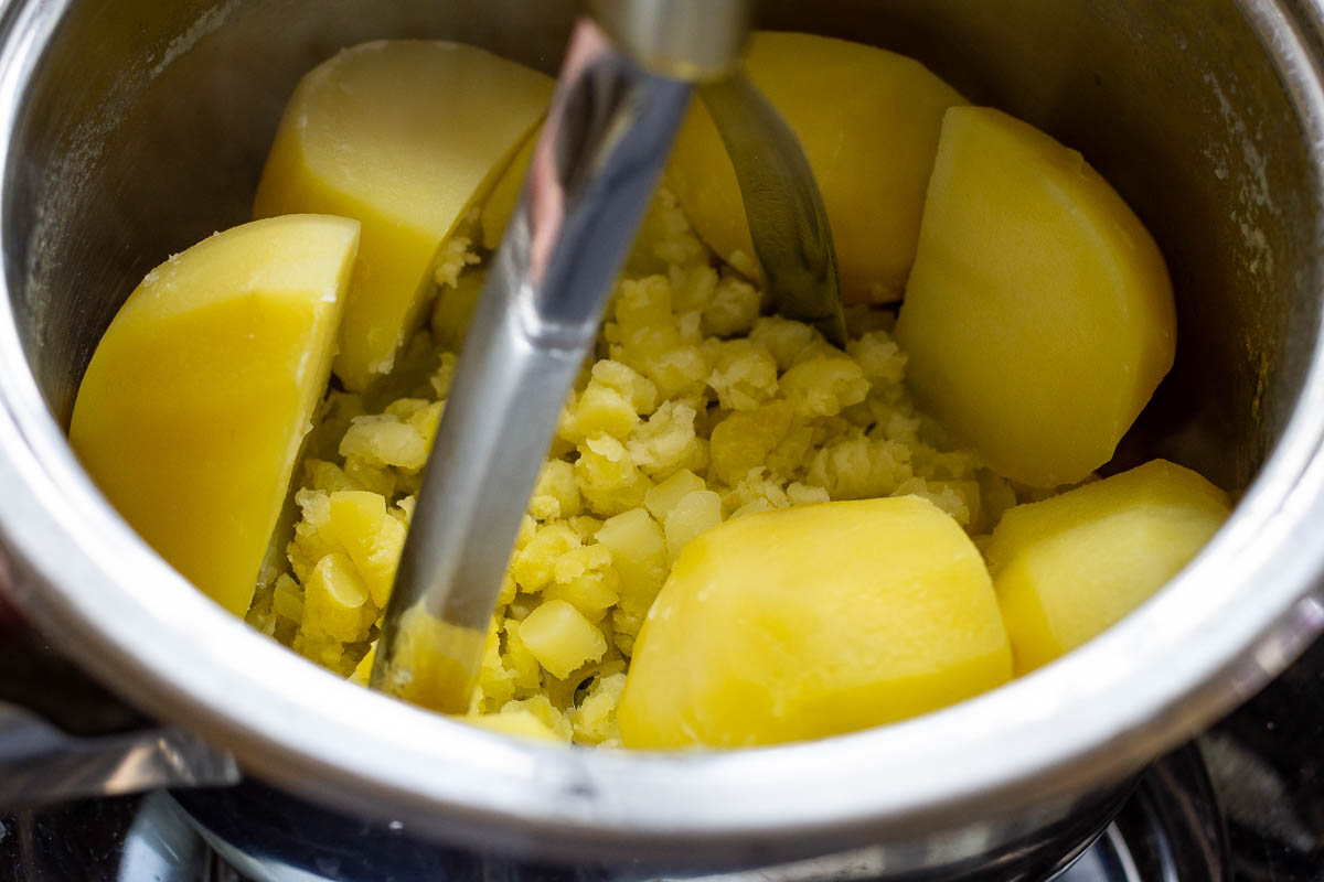 Mashing boiled potatoes.