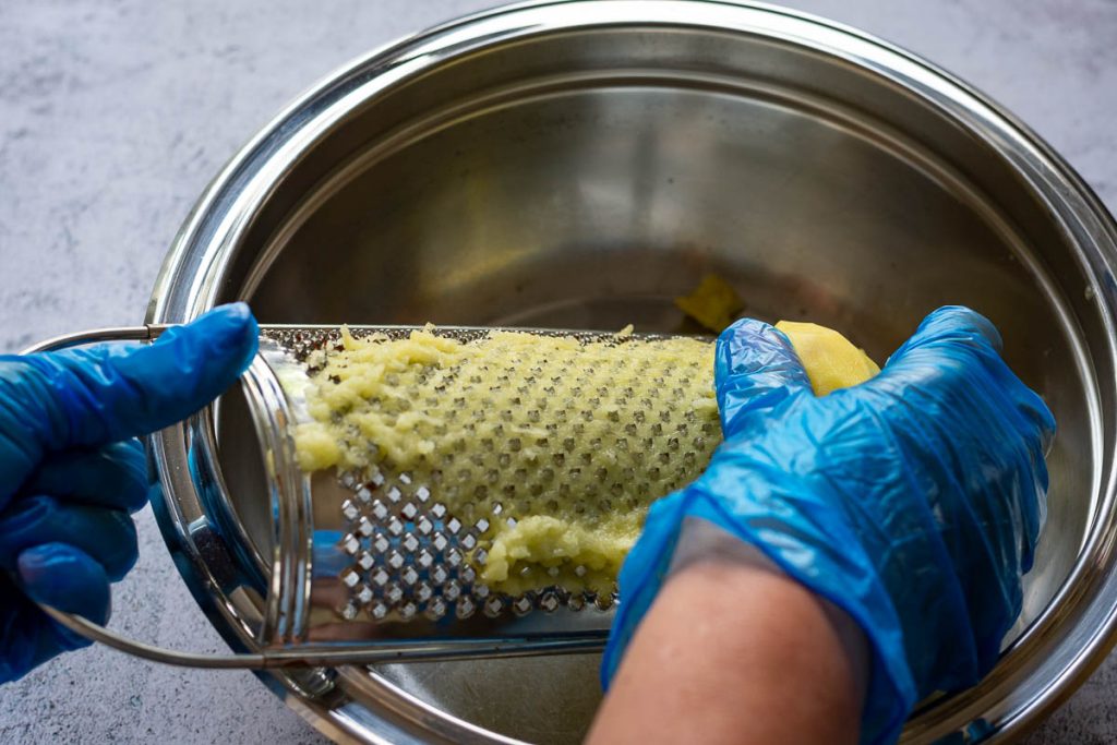 Grating raw potatoes.