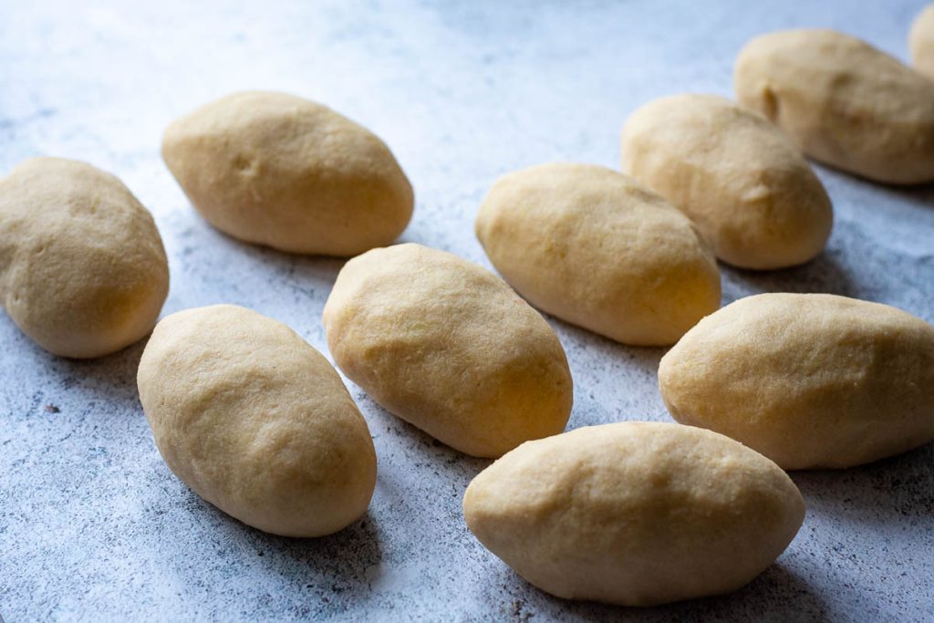 Shaped Lithuanian Potato dumplings on a clean kitchen surface.