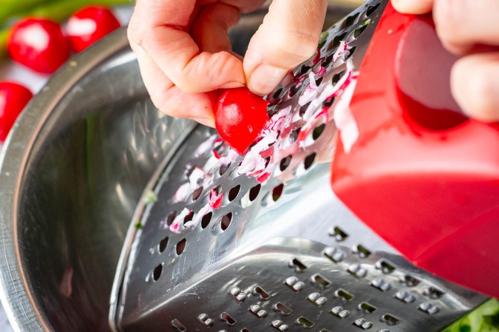 Coarsely grating radishes.