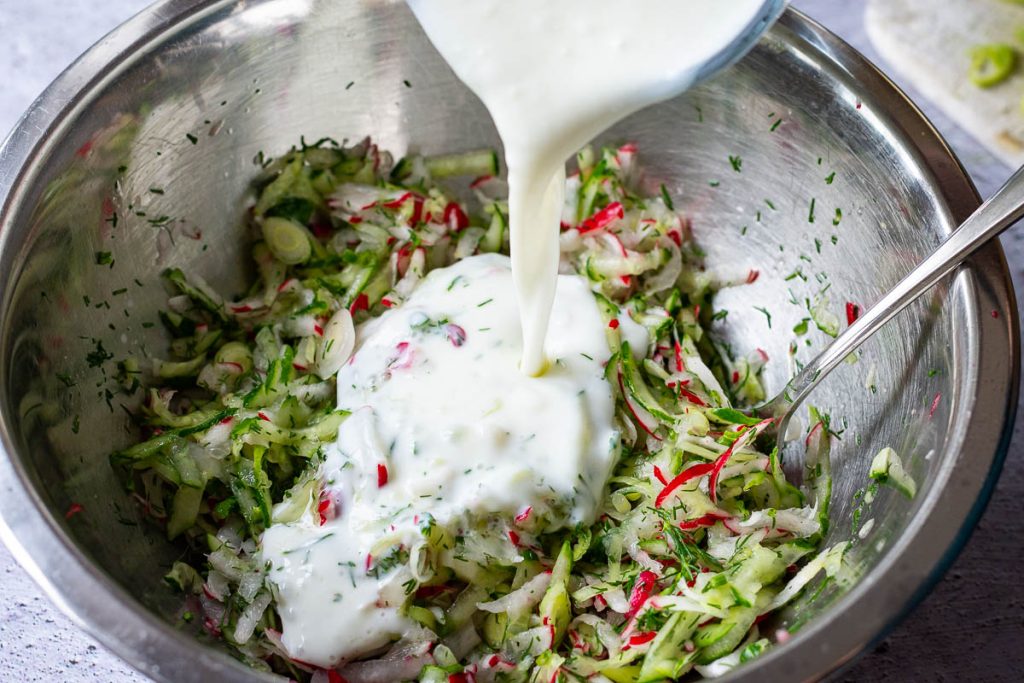 Pouring kefir over the vegetables.