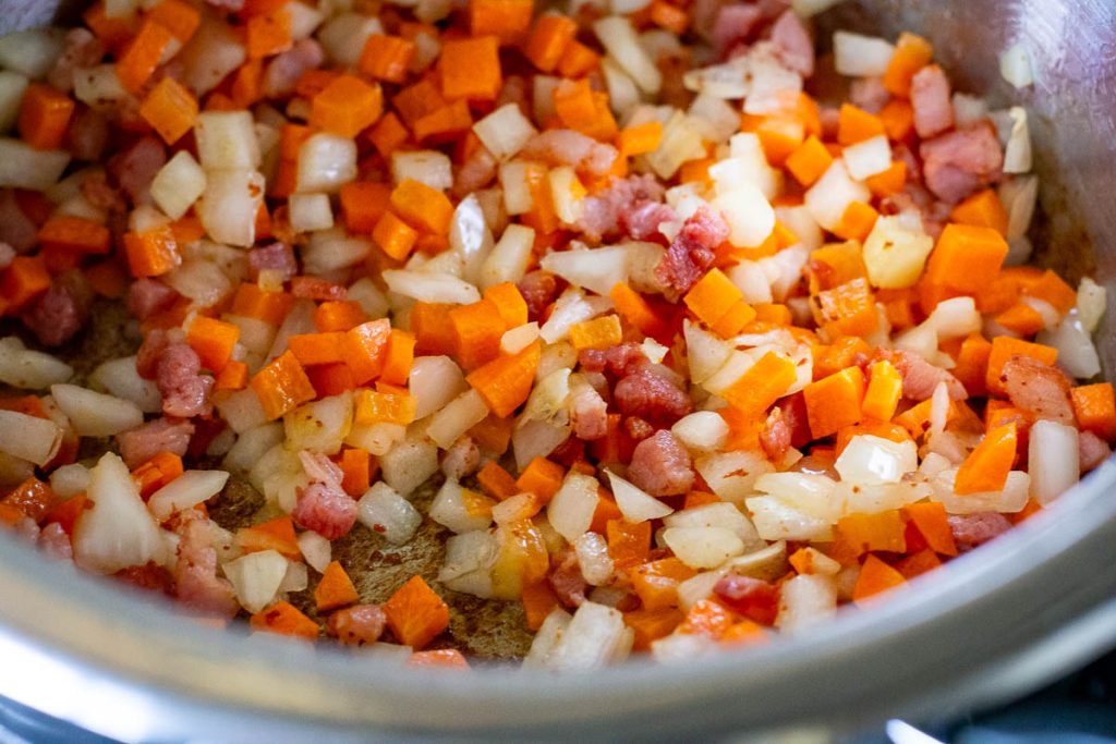 Bacon, carrots and onion in a large pot sauteeing.