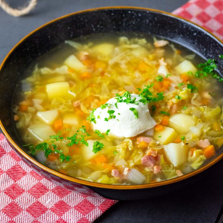 Lithuanian Cabbage soup with bacon served with a dollop of sour cream.