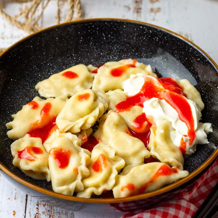 Lithuanian Dumplings with sweet curd cheese filling served with sour cream and strawberry coulis.