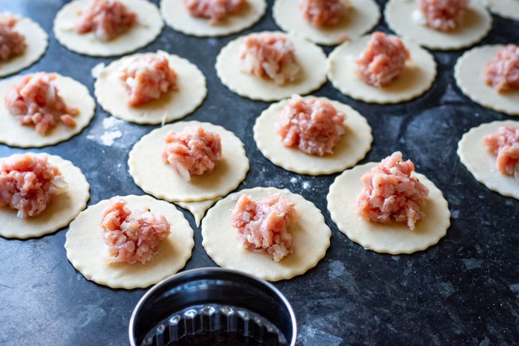 A spoonful of pork filling on top of each dough circle. 