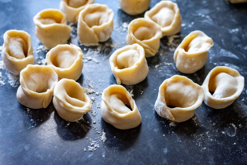 Shaped Lithuanian pork dumplings on a floured kitchen worktop. 
