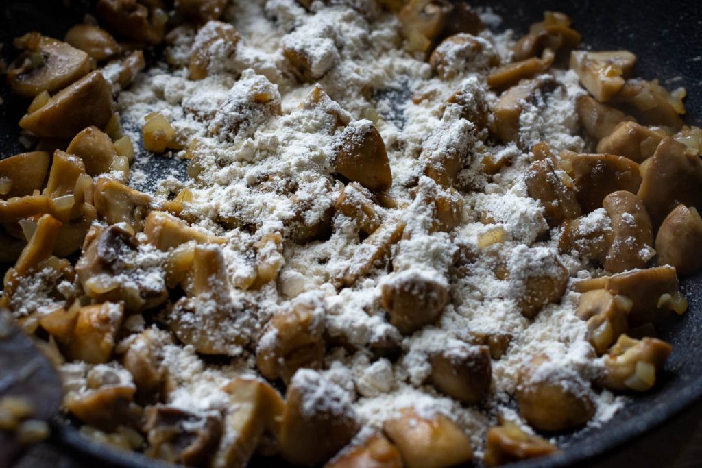 Flour sprinlled over the mushrooms and onions.