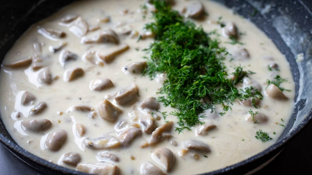 Creamy sauce after sour cream is added with fresh dill on top.
